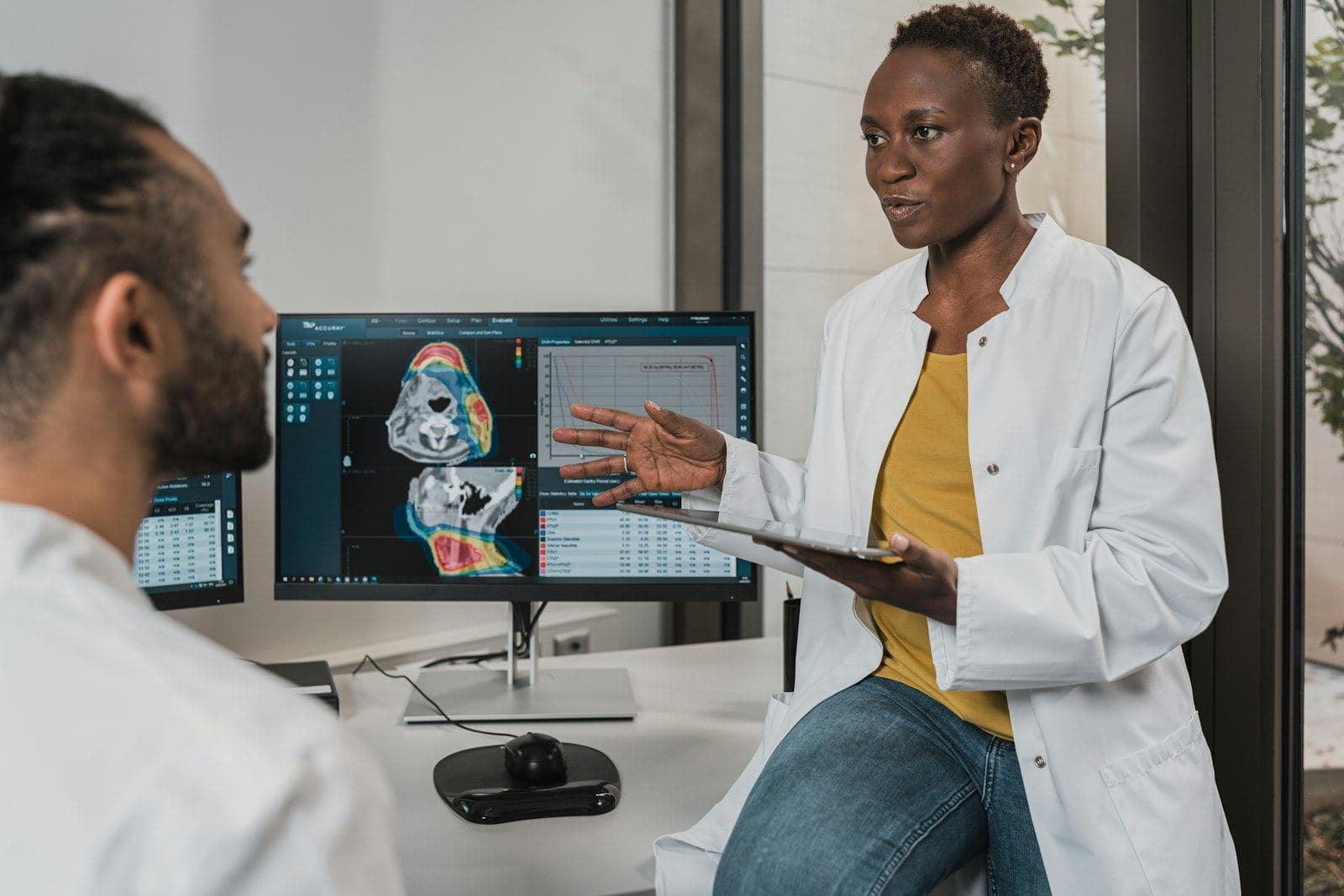 Clinicians reviewing imaging on a tablet and monitor